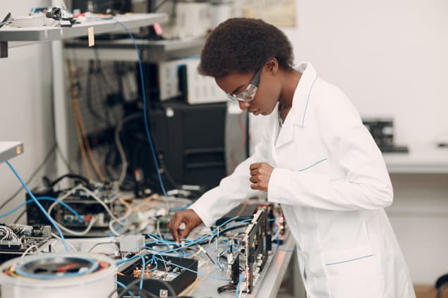 Black scientist working at an electronics bench Black scientist working at an electronics bench