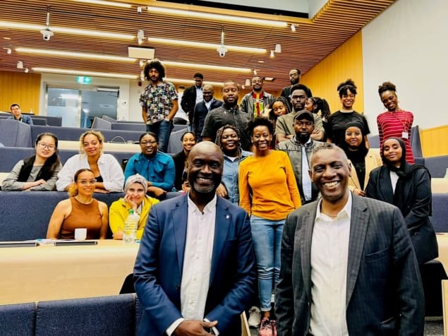 Blackett Lab Family A photo of Mark Richards and Washington Ochieng, together with a large group of Black physicists, in a lecture theatre