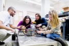 Group of students in physics and engineering working on electronics robotics project in laboratory session